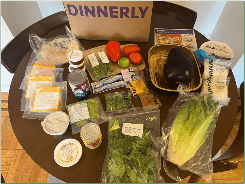 A Dinnerly box unpacked with ingredients in front of it