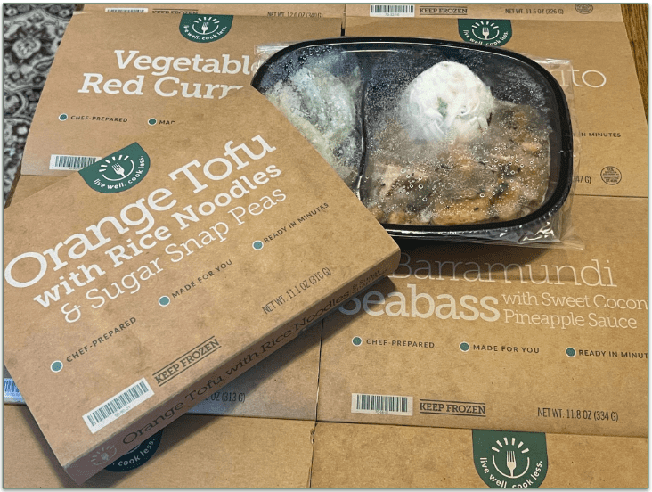 Spread of BistroMD meals in their trays with Orange Tofu on the top