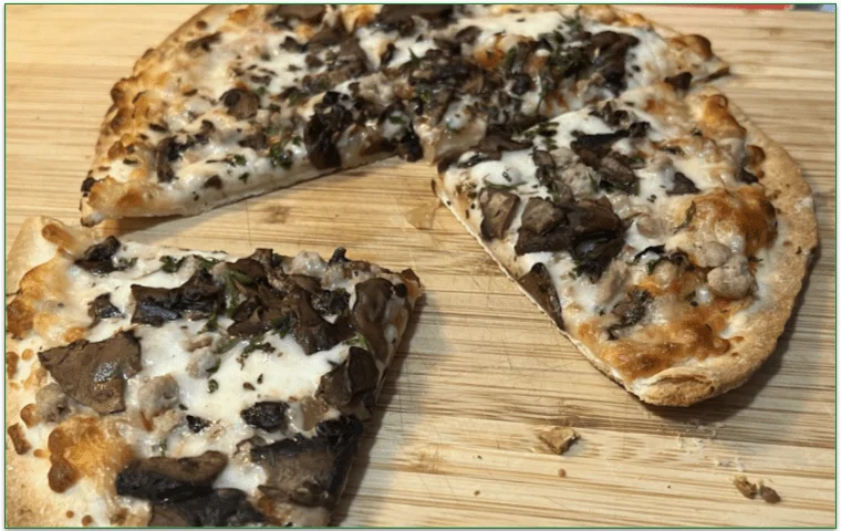Photo of Nutrisystem's Caramelized Onion, Mushroom and Turkey Sausage Pizza sliced into 4 on a board
