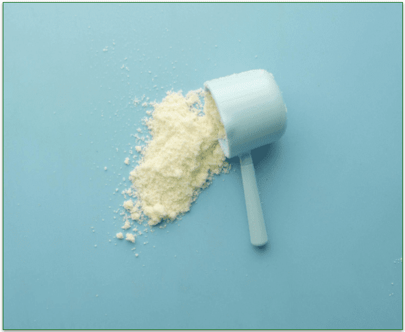 Spilled protein powder next to an empty scoop