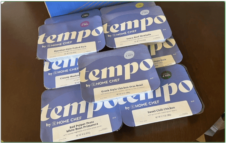 Photo of a pile of Tempo prepared meals next to the Tempo delivery box