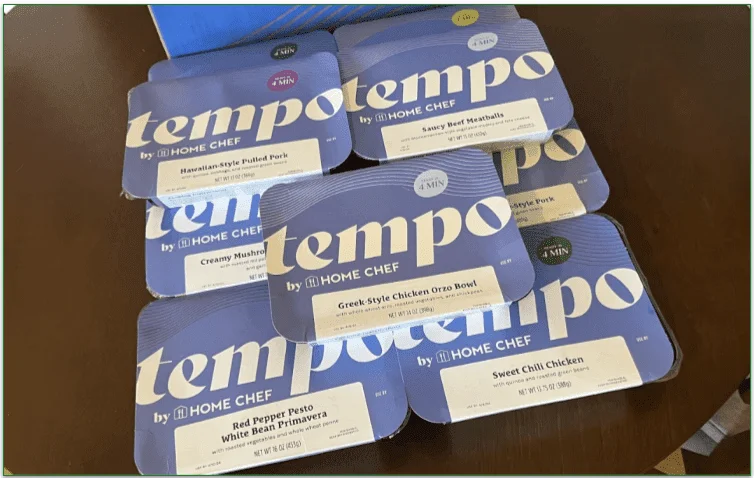 Photo of a pile of Tempo prepared meals next to the Tempo delivery box