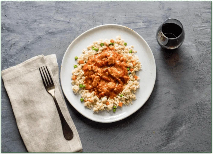 A Veestro meal served on a plate with a drink and fork