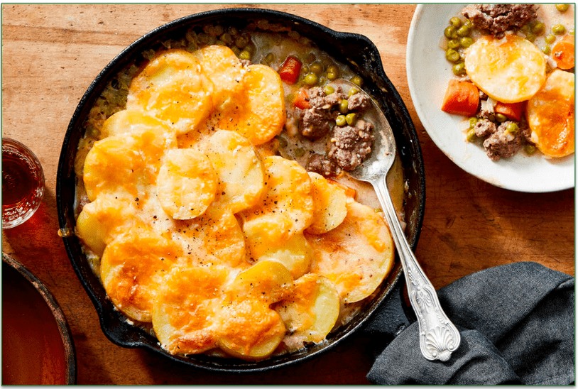 A skillet with ground beef topped with roasted sliced potatoes