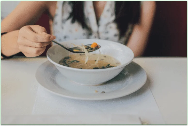 Woman eating a bowl of soup