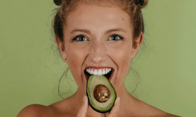 Woman biting an avocado