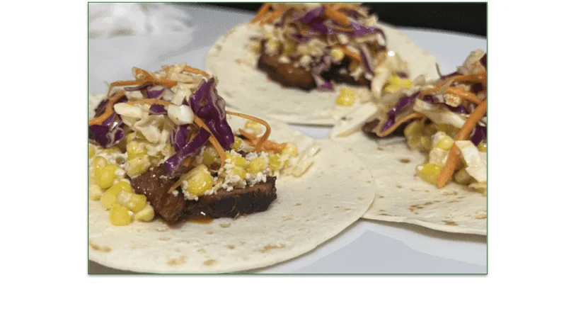Image of the Spicy Brisket Elotes Tacos served on a plate