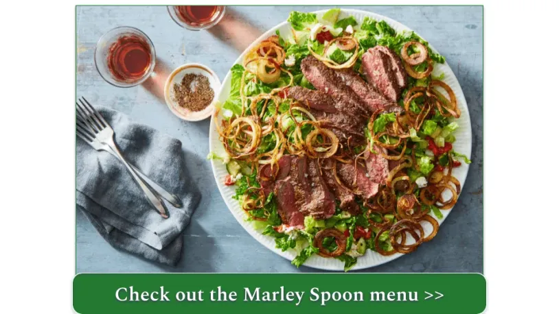 A plate of steak and fried shallots atop a bed of greens