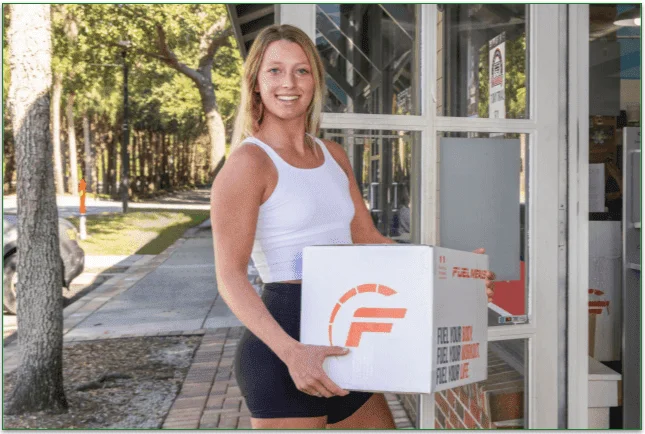 Woman holding a Fuel Meals package