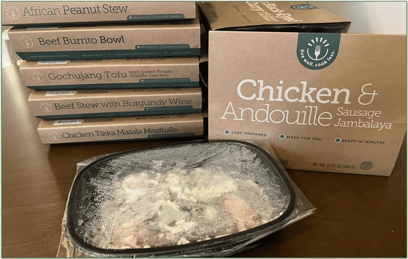 Photo of a stack of BistroMD meals with one meal taken out of the cardboard packaging