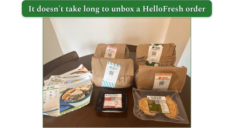 4 paper bags each containing ingredients for a HelloFresh recipe with recipe cards in front