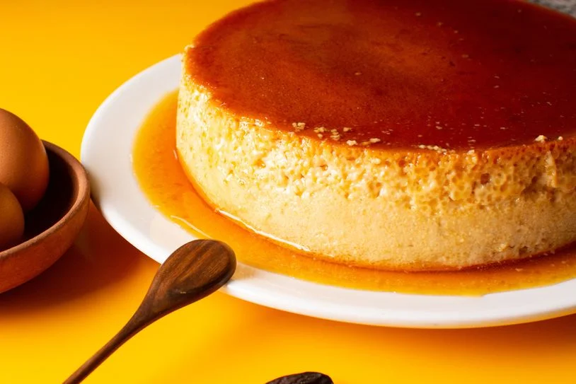 Leche flan on a plate with a yellow background