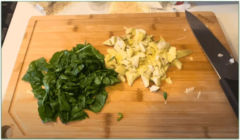 Spinach and artichoke chopped on a board
