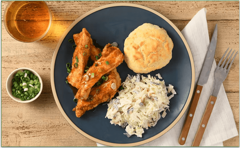 A plate of chicken with a biscuit and slaw