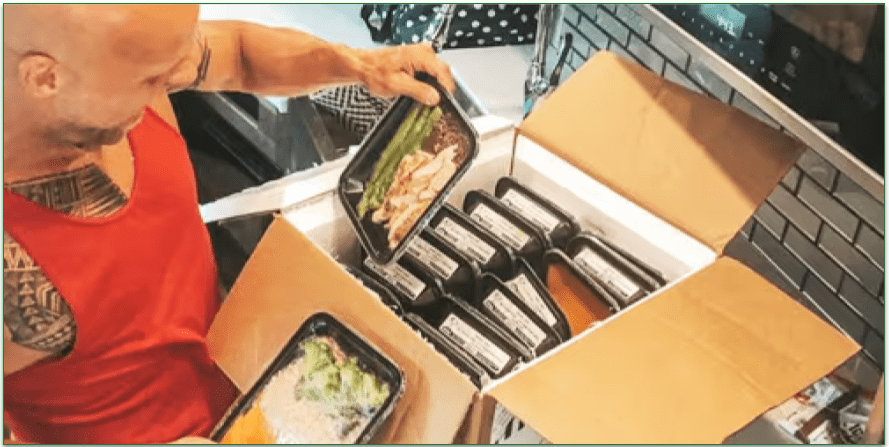 A man unpacking a box of Icon Meals