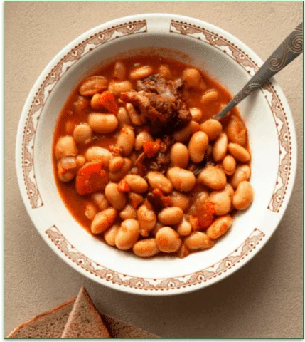 A serving of Baked Beans and Pork Chops, on a plate