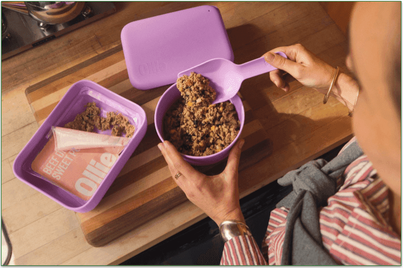 A person scooping Ollie's fresh beef meal into a bowl from a container